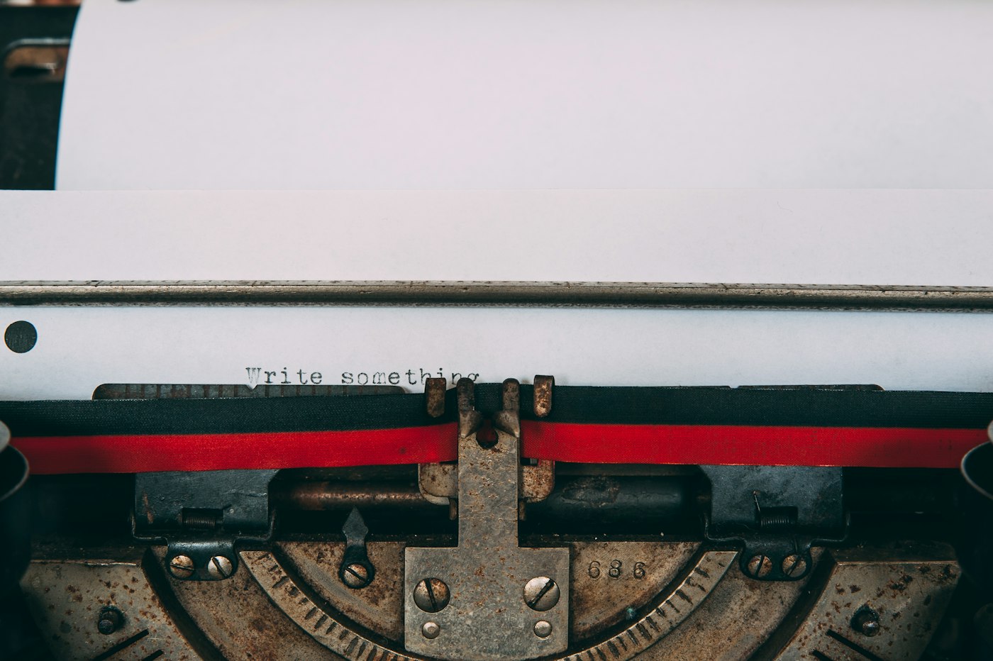 Paper in a vintage typewriter, with the words Write something above the ribbon.
