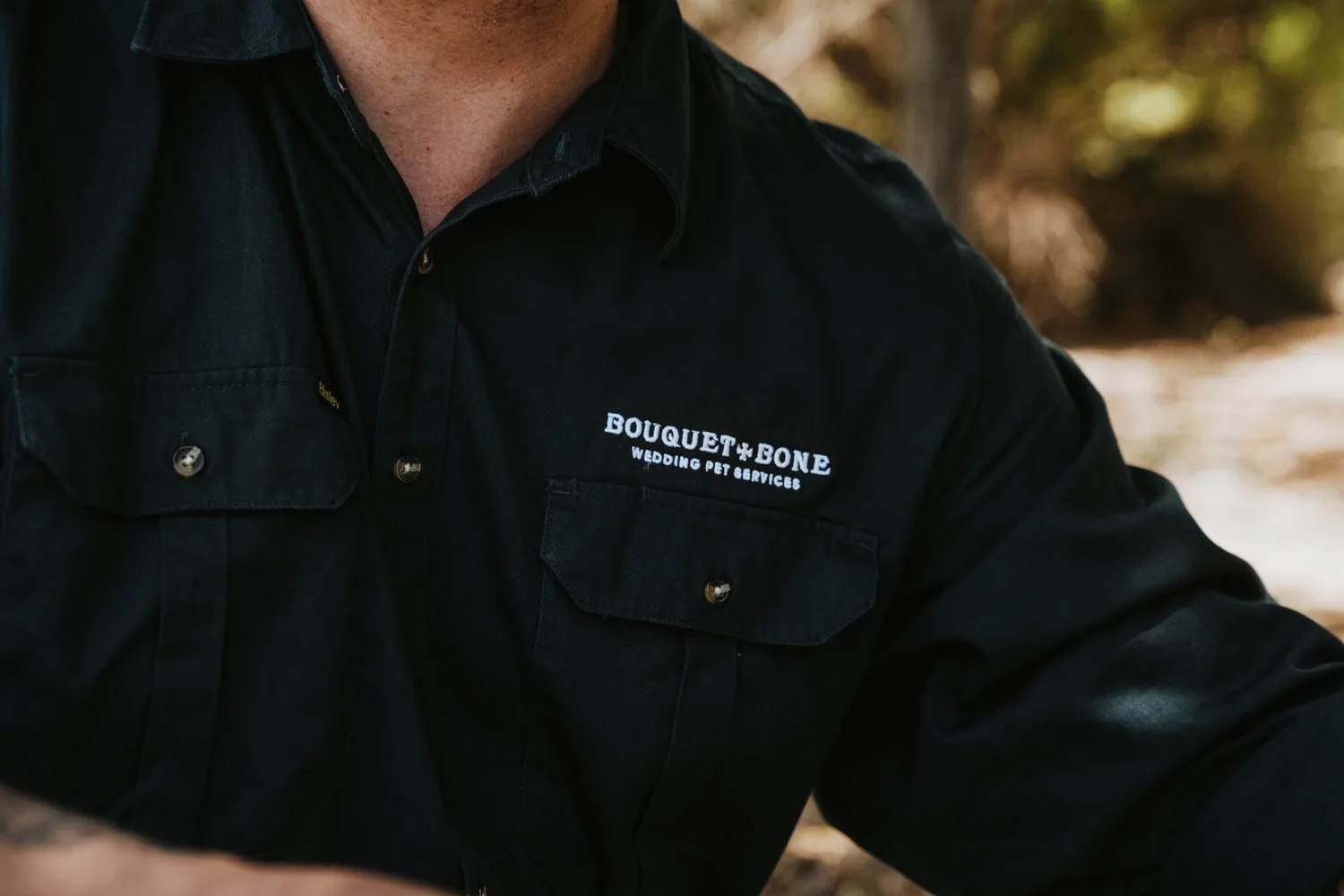 The Bouquet & Bone name on a dark work shirt.